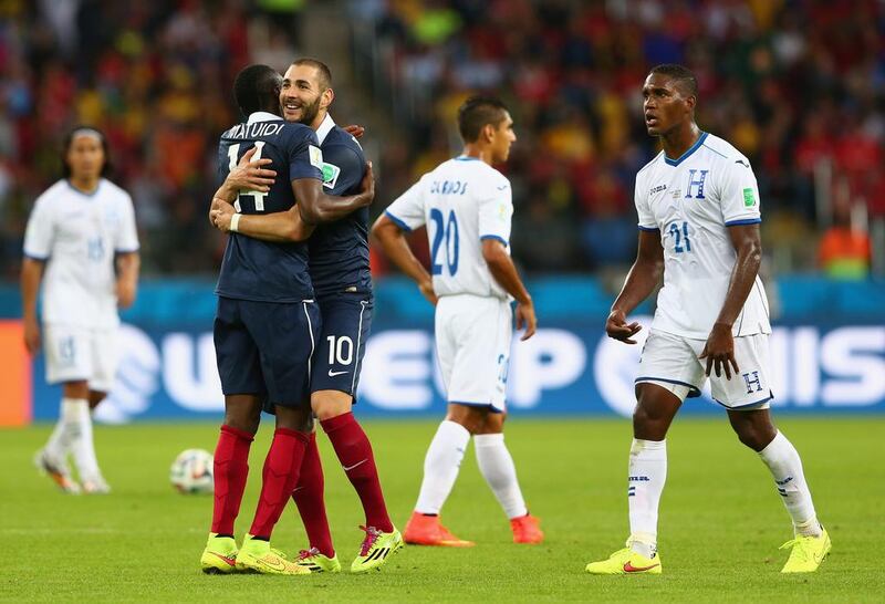 Karim Benzema of France, second left, celebrates after scoring his team's third goal with Blaise Matuidi as Brayan Beckeles of Honduras looks on during France's 3-0 win on Sunday at the 2014 World Cup in Porto Alegre, Brazil. Quinn Rooney / Getty Images