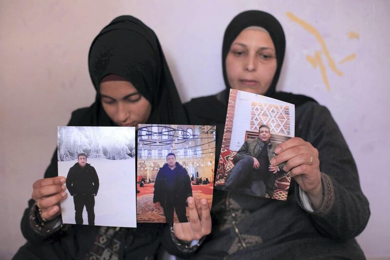 The family hold the photo of xxx. Photo by Sanad Latefa