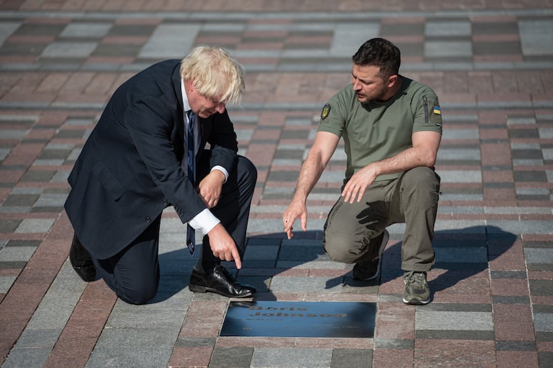 Ukrainian President Volodymyr Zelenskyy and Mr Johnson look at a plaque dedicated to Johnson in Kyiv in August 2022