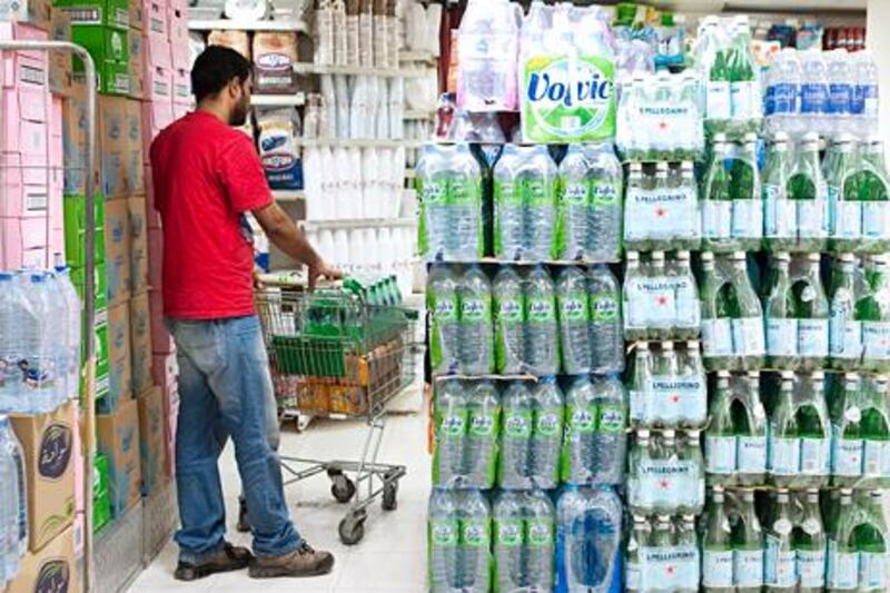 Dubai, Mar 28 2012 -- STOCK - A man walks past a display of bottled water  at Spinneys grocery store in Dubai, March 28, 2012.  (Sarah Dea/ The National)