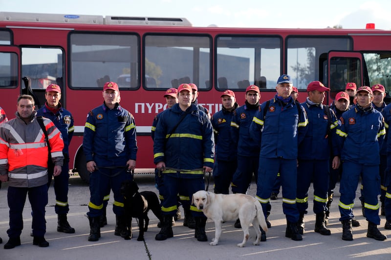 Greek firefighters with rescue dogs wait to board a military plane at Elefsina Air Force Base, in western Athens, Greece. AP