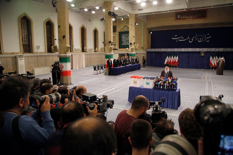 Mr Khamenei speaks to the media after casting his vote in Tehran. EPA