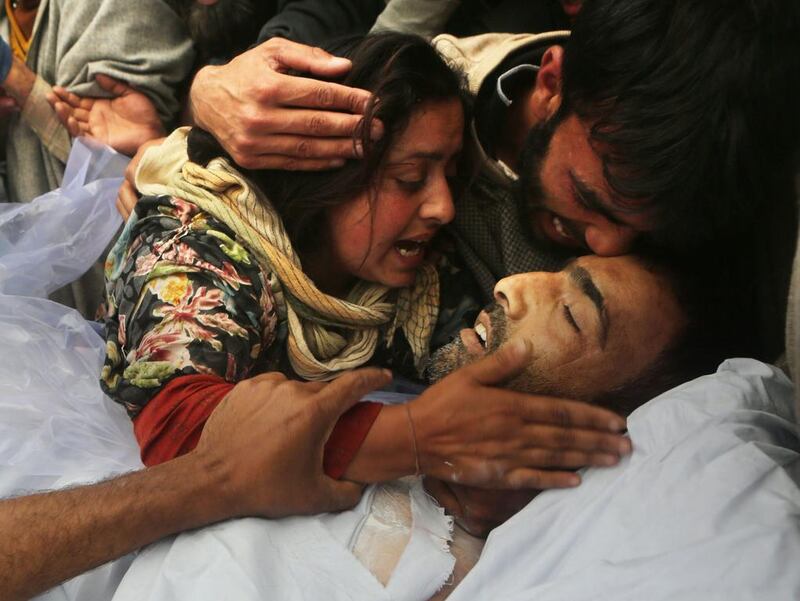 The wife of husband Mushtaq Ahmad Mir hugs her dead husbands body, during his funeral procession in Qazipora, India.  Farooq Khan / EPA