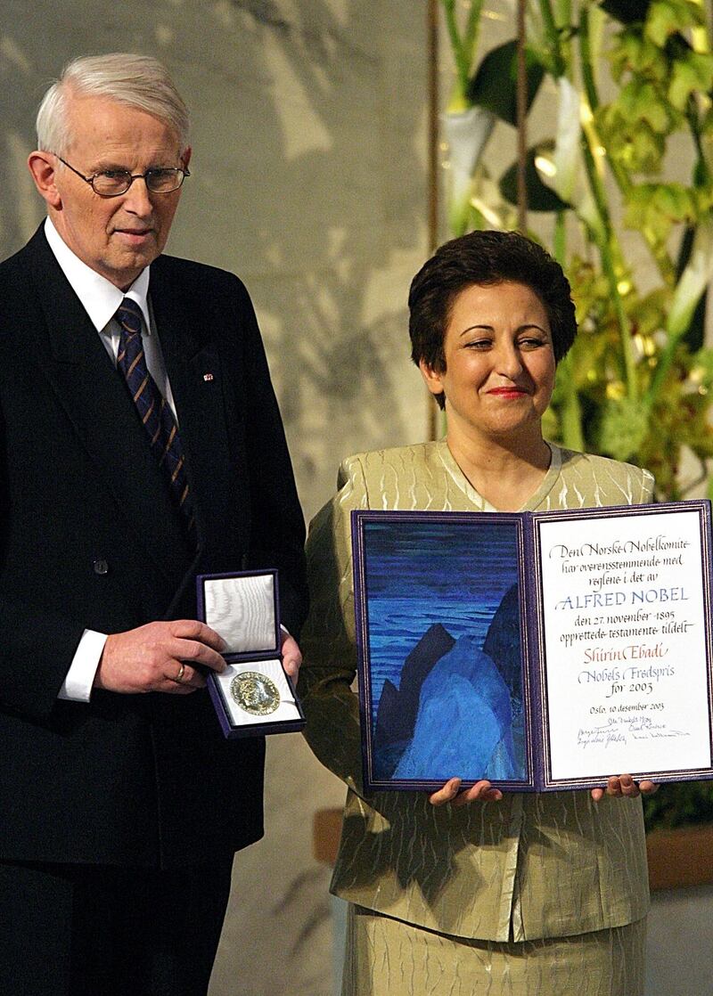 Iranian lawyer and human rights activist Shirin Ebadi (R) and Nobel Committee chairman Ole Danbolt Mjoes (L) poses with the medal and diploma after Ebadi was awarded the 2003 Nobel prize during a ceremony in Oslo's city hall 10 December 2003. Ebadi, 56, received the Nobel Peace Prize at a ceremony in Oslo on Wednesday for her democracy-building efforts and her work to improve human rights in Iran, making her the first Muslim woman to receive the award.AFP PHOTO / ODD ANDERSEN (Photo by ODD ANDERSEN / AFP)