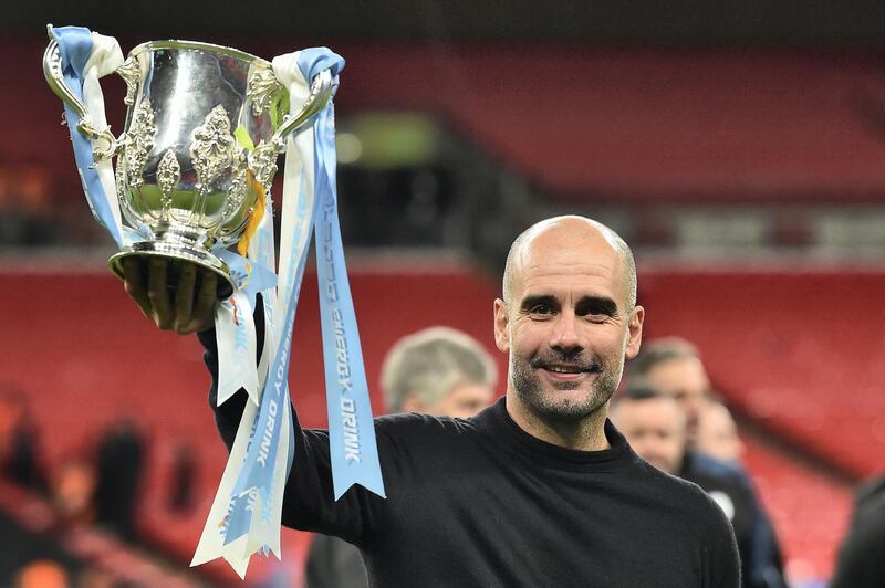 Manchester City's Spanish manager Pep Guardiola celebrates with the trophy on the pitch after the English League Cup final football match between Aston Villa and Manchester City at Wembley stadium in London on March 1, 2020. - Manchester City won the game 2-1. (Photo by Glyn KIRK / AFP)