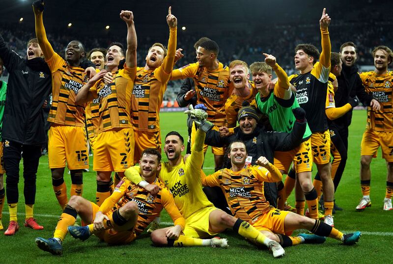 Cambridge United players celebrate after beating Newcastle United in the FA Cup third-round match at St James' Park on Saturday January 8. PA