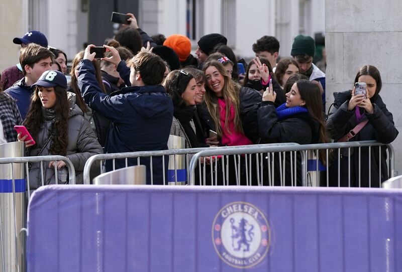 Fans take pictures outside Stamford Bridge. PA