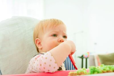 Baby eating with hands avocado sandwiches 