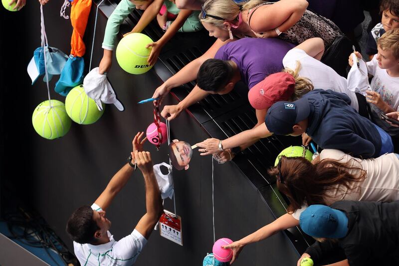 Serbia's Novak Djokovic gives autographs after victory against Japan's Yoshihito Nishioka in Melbourne, Australia. AFP