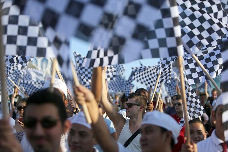 Two hundred and fifty eight people set a new world record on Abu Dhabi’s Corniche for the most number of people waving chequered flags in one place.  Sammy Dallal / The National