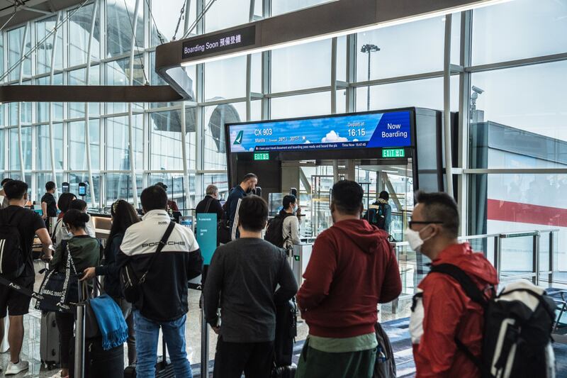 Travellers queue to board a Cathay Pacific flight at Hong Kong International Airport.  Bloomberg