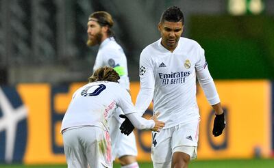 Real Madrid's scorer Casemiro, right, shakes hands with Real Madrid's Luka Modric after he scored the 2-2 during the Champions League group B soccer match between Borussia Moenchengladbach and Real Madrid at the Borussia Park in Moenchengladbach, Germany, Tuesday, Oct. 27, 2020. (AP Photo/Martin Meissner)