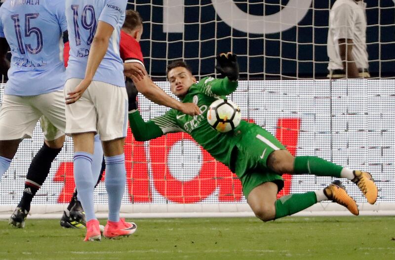 Manchester City's goalkeeper Ederson, right, stops a shot by Manchester United's Phil Jones, second from right. David J. Phillip / AP Photo