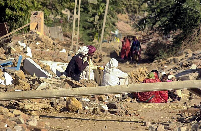 Homeless villagers wait for  relief in Bondh village in Bhuj district 28 January 2001 after their village was destroyed in an earthquake that struck north western India 26 January 2001, rendering thousands homeless. At least 15000 people are feared dead as a result of the tremor, with casualties expected to rise. AFP PHOTO/Arko DATTA (Photo by ARKO DATTA / AFP)