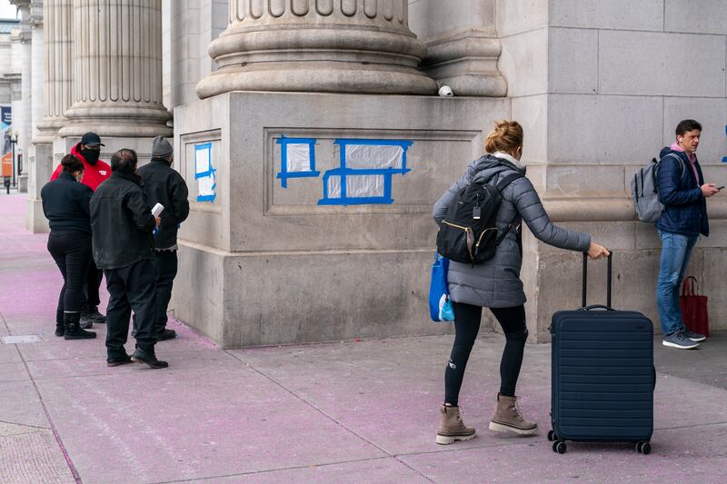 Blue tape and plastic cover swastikas drawn by vandals on the front of Union Station. AP