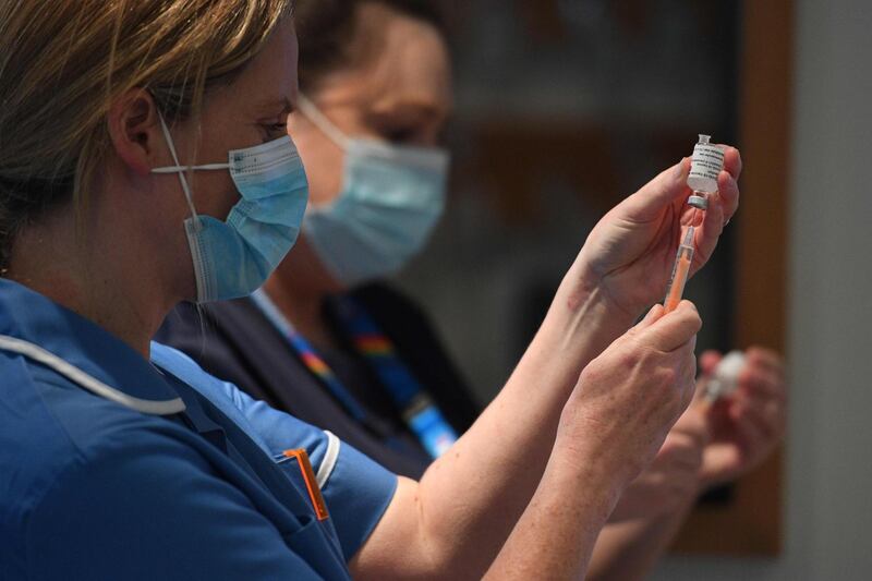 A healthcare professional draws up a dose of AstraZeneca vaccine in a syringe at the vaccination centre at Chester Racecourse. AFP