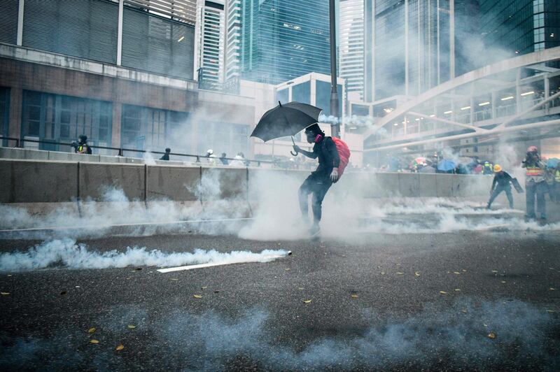 Protesters react after police fired tear gas outside the government headquarters in Hong Kong.  AFP