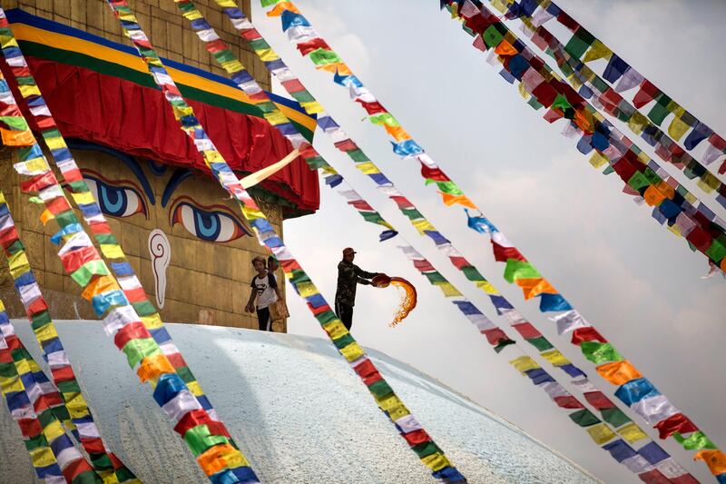 A pilgrim spreads colour at the Bauddhanath stupa in Kathmandu, Nepal. EPA