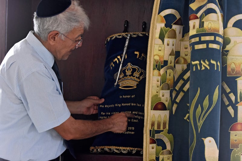 Mr Nonoo unfolds the Torah scrolls. AFP
