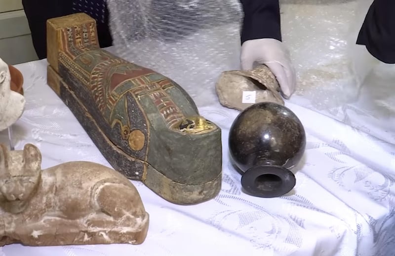 Egyptian experts and officials inspect recovered smuggled artefacts at the embassy in Paris. Screengrab