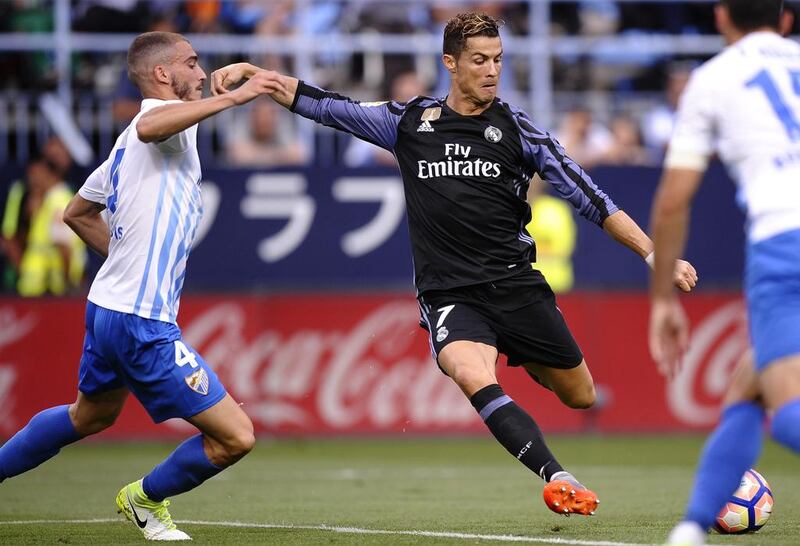 Real Madrid’s Cristiano Ronaldo fights for the ball against Malaga’s Mikel Villanueva. Daniel Tejedor / AP Photo