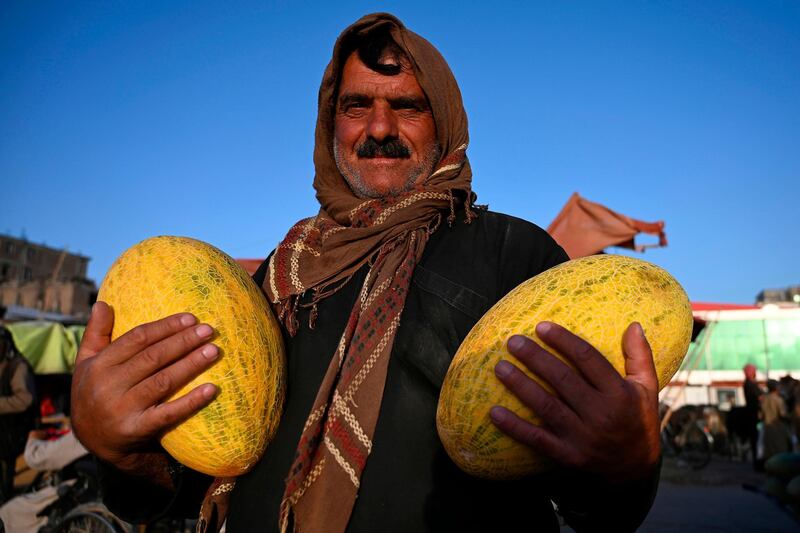 A vendor holds melons  as he waits for customers at a fruit market in Kabul.   AFP