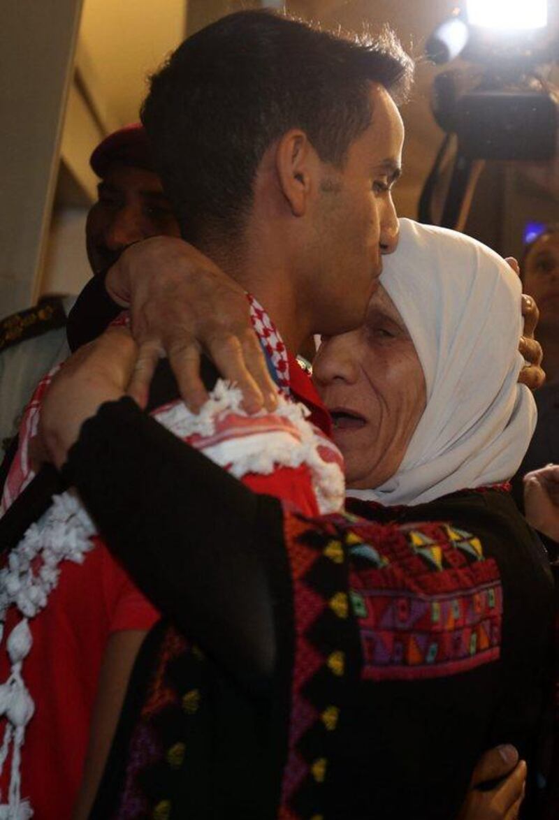 Ahmed Abughaush, left, kisses his mother. Khalil Mazraawi / AFP