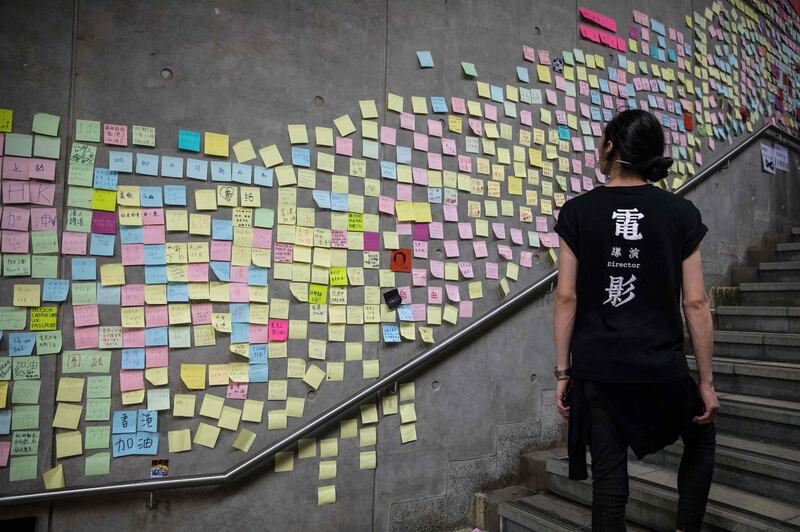 A protester looks at messages left by demonstrators outside the government headquarters after a rally against a controversial extradition law proposal in Hong Kong.  AFP