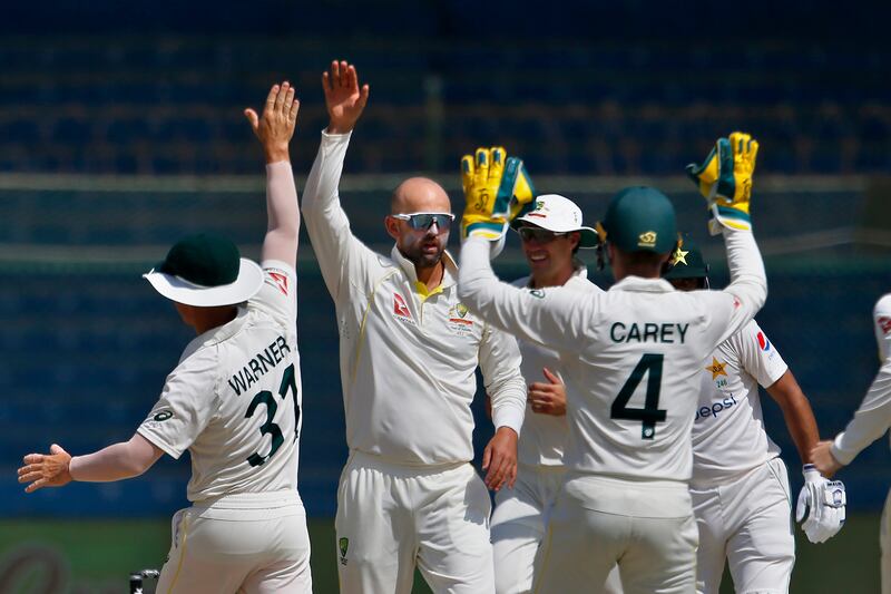 Australia's Nathan Lyon, second left, celebrates with teammates after taking the wicket of Imam-ul-Haq for one. AP