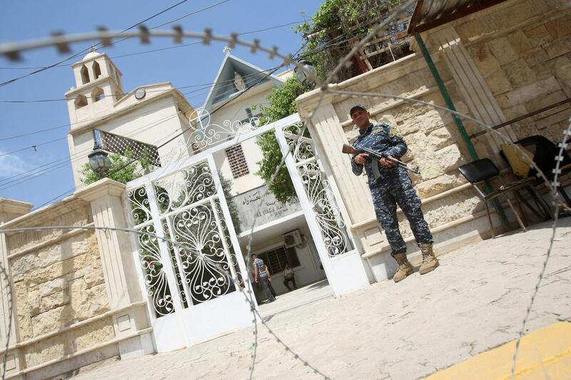 A police officer guards the Church of the Virgin Mary, Baghdad, on Easter Sunday, 2011. The Baghdad Eucharist gives an Iraqi Christian perspective on their besieged life in the city. Ahmad Al Rubaye / AFP 