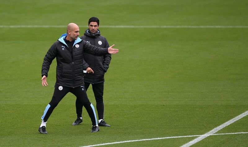 Pep Guardiola, left, talks to Mikel Arteta. PA