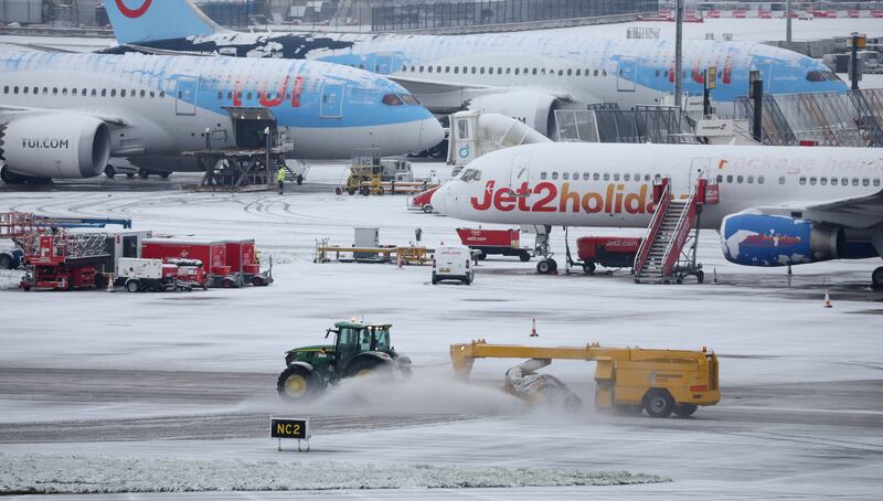 A tractor clears snow from the runways at Manchester Airport. Reuters