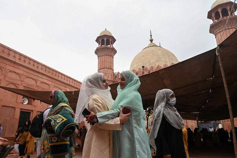 Muslim women greet each other after prayers in Lahore. AFP
