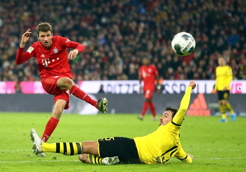 Dortmund's Mats Hummels, front, tries to block a shot from Thomas Muller. AP Photo
