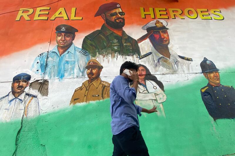 A pedestrian walks past a wall mural thanking frontline workers following restrictions imposed by the state government amidst rising Covid-19 coronavirus cases, in Mumbai. AFP