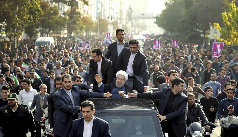 Iranian president Hassan Rouhani, centre, waves to his well-wishers from his car during a public welcoming ceremony for him upon his arrival in Karaj, 35 kilometres west of the capital Tehran, Iran on November 16, 2016. Rouhani says his country will remain committed to a landmark nuclear deal with world powers regardless of the US presidential election result. Iranian Presidency Office via AP