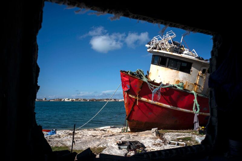 A ship ran aground by the winds of Hurricane Dorian is seen through the broken wall of a house destroyed by the storm, in Abaco, Bahamas.  AP