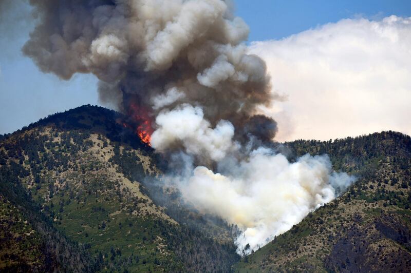 A plume of smoke rises as a wildfire consumes trees in  La Veta, Colorado. Helen H Richardson / The Denver Post via AP