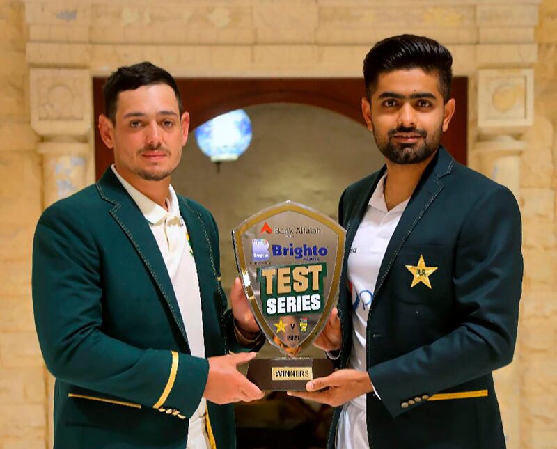 In this photo provided by Pakistan Cricket Board, Pakistan cricket team's skipper, Babar Azam, right, and his South Africa's counterpart Quinton de Kock pose for a photograph with the trophy of test-series, in Karachi, Pakistan, Monday, Jan. 25, 2021. Pakistan and South Africa will play the first test match on Jan. 26. (Pakistan Cricket Board via AP)