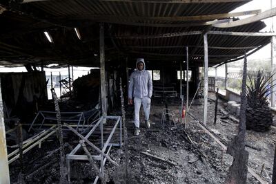 MITILINI, GREECE - MARCH 08: A volunteer in the burnt facilities of the school for refugee children, part of the "One Happy Family" NGO's project on the island of Lesbos on March 8, 2020 in Mitilini, Greece. The fire at One Happy Family, a Swiss-operated family care centre for refugees just outside the island capital, came after violence at the weekend directed at aid groups and journalists on Lesbos. (Photo by Milos Bicanski/Getty Images)