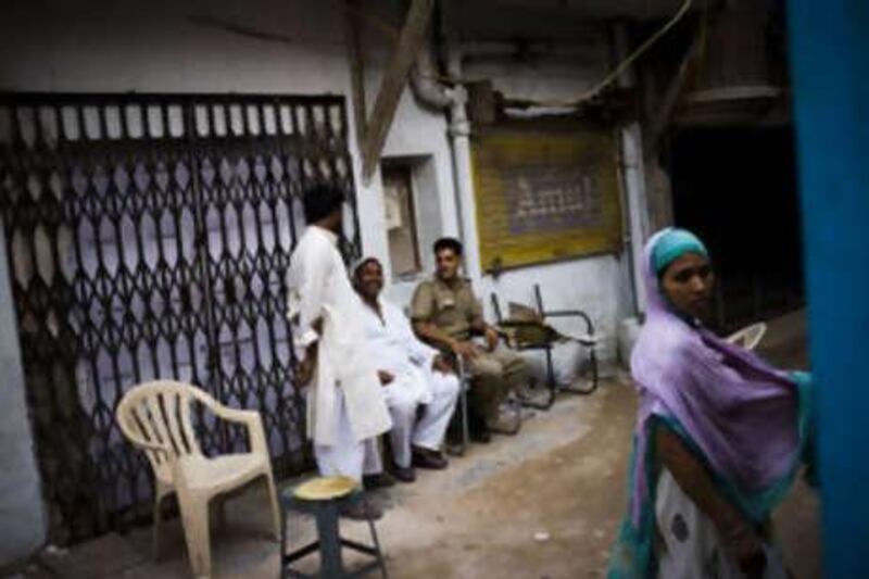A New Delhi policeman shares a lighter moment with local residents outside the house in Jamia Nagar where Mohammed Sajid was killed.