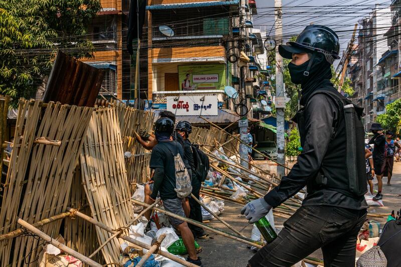 Protesters stand behind a barricade while waiting for security forces to approach in Yangon. Getty Images