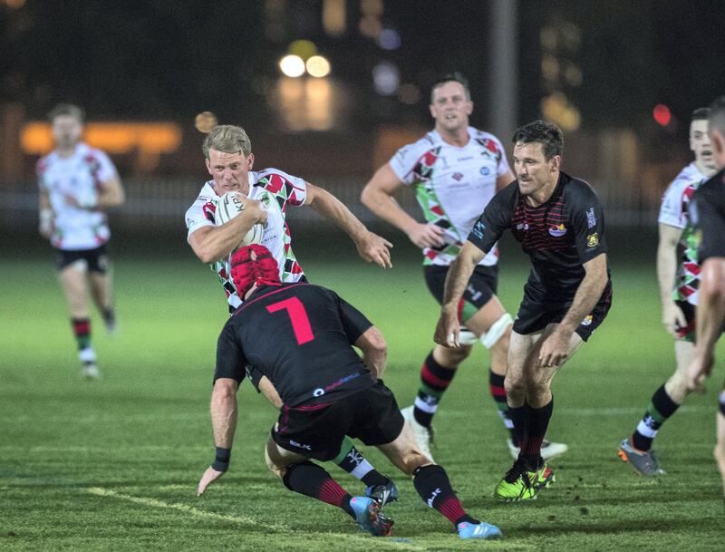 Abu Dhabi, UAE, March1 ,2018.   
West Asia Premiership - Abu Dhabi Harlequins v Abu Dhabi Saracens.  Tom Brown of the Harlequins (white-center) slips through the Saracens defense.
Victor Besa / The National
Sports
Reporter:  Paul Radley