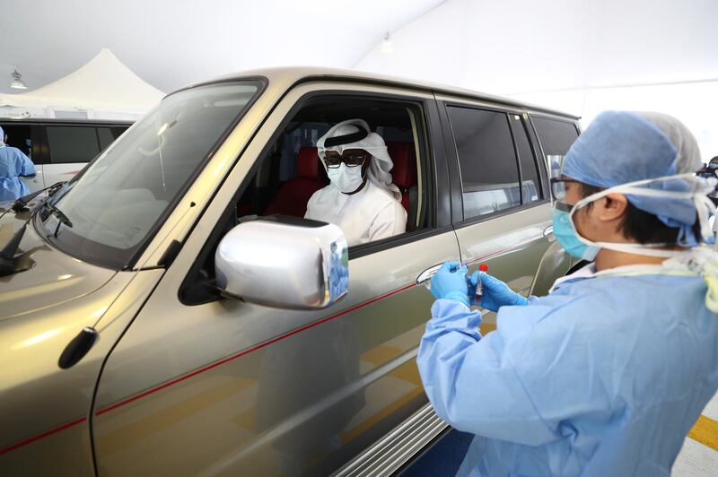 A health worker takes swab sample at a coronavirus drive-through screening centre in Abu Dhabi.