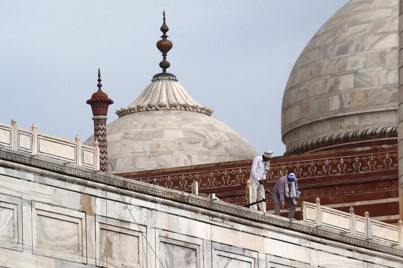 In this picture taken on May 30, 2020, workers stand on the railing of the Taj Mahal after it was damaged due to heavy rainstorm in Agra.  / AFP / Pawan Sharma
