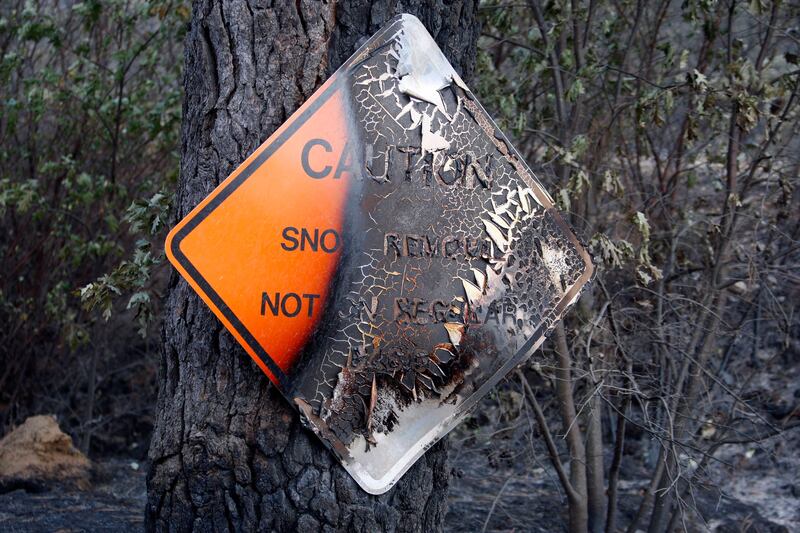 A charred caution sign which warns that winter snow removal is not done on a regular basis is seen at the Rim Fire just outside of Yosemite National Park, California, August 27, 2013. The Rim Fire, one of the largest California wildfires on record roared deeper east into Yosemite National Park on Tuesday, frightening away many late-summer visitors, while the sprawling blaze also crept closer to thousands of homes west of the park. REUTERS/David McNew (UNITED STATES - Tags: ENVIRONMENT DISASTER) *** Local Caption ***  DLM007_USA-FIRE-YOS_0828_11.JPG