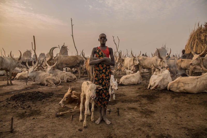 Sudanese girl Den, 14, from the Dinka tribe, works as a cattle keeper, cook and cleaner and aid to her brother.