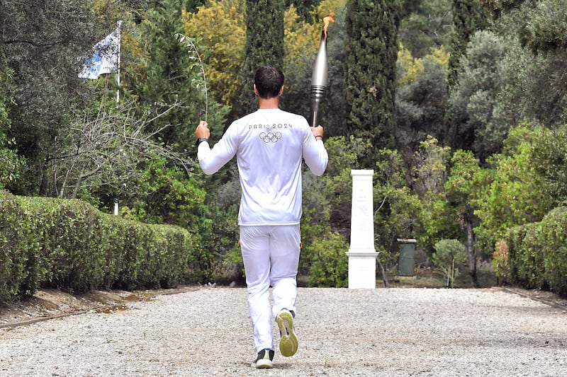 Ntouskos carries the Olympic torch. It will now journey across Greece before coming to France. EPA 