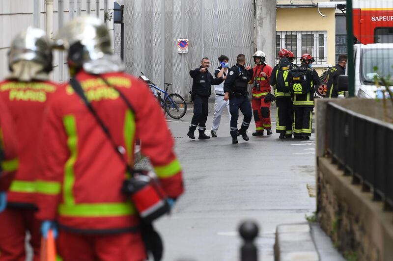 Firefighters move an injured person into a waiting ambulance. AFP