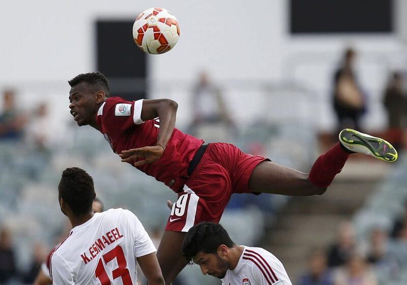 Qatar's Mohammed Muntari jumps for the ball over UAE players during their Asian Cup Group C match on Sunday in Canberra, Australia. Tim Wimborne / Reuters